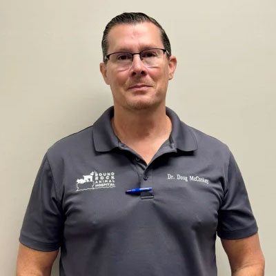 dr. douglas mcconkey wearing a grey polo shirt and smiling