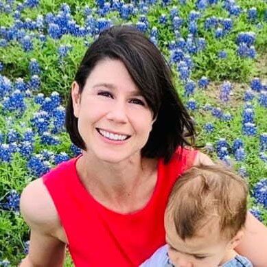 dr maynor sitting beside flowers while a small child is sitting on her lap