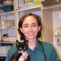 dr sharon waters smiling and holding a black and white cat
